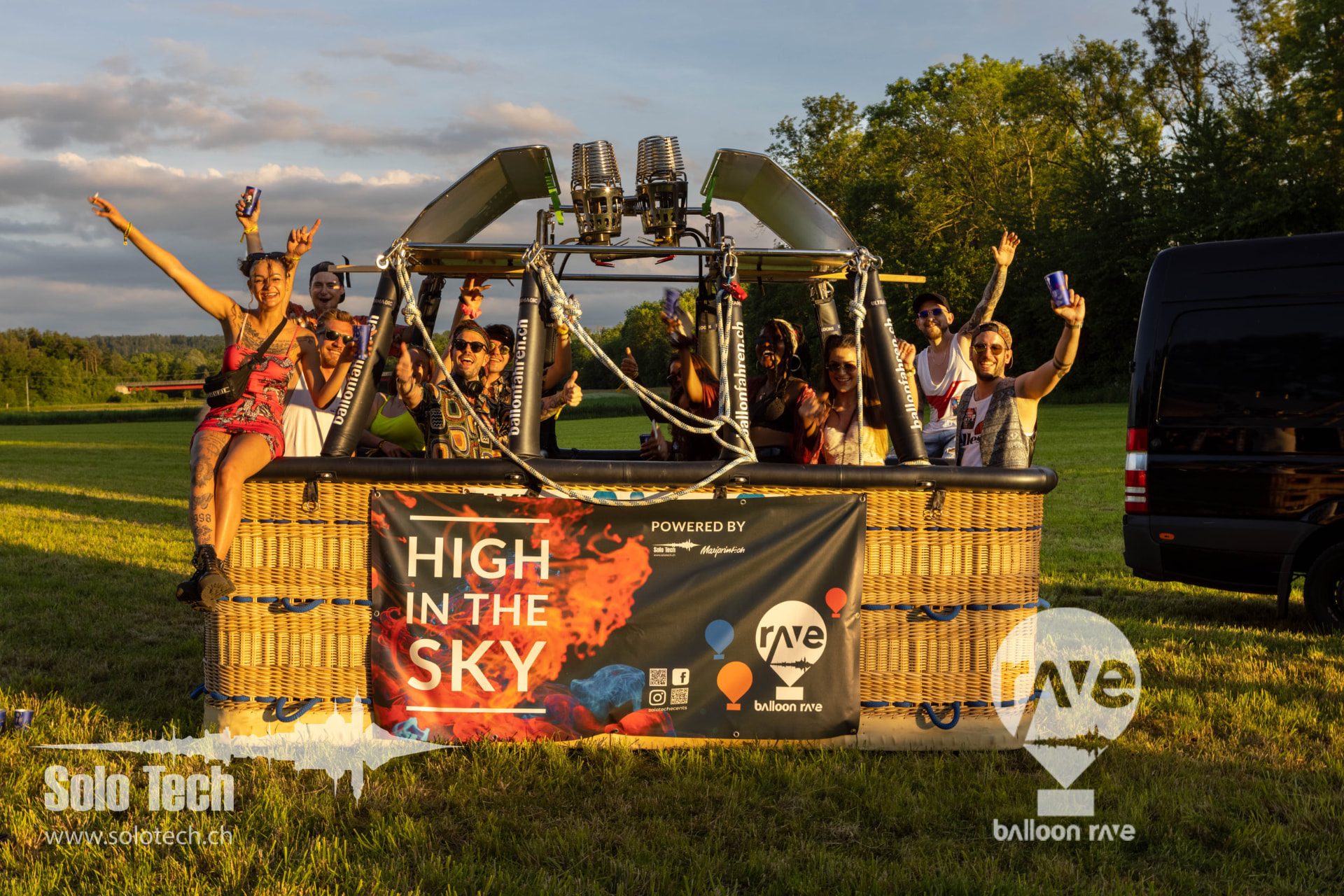 Gäste im Ballonkorb mit High in the Sky Banner im Abendlicht
