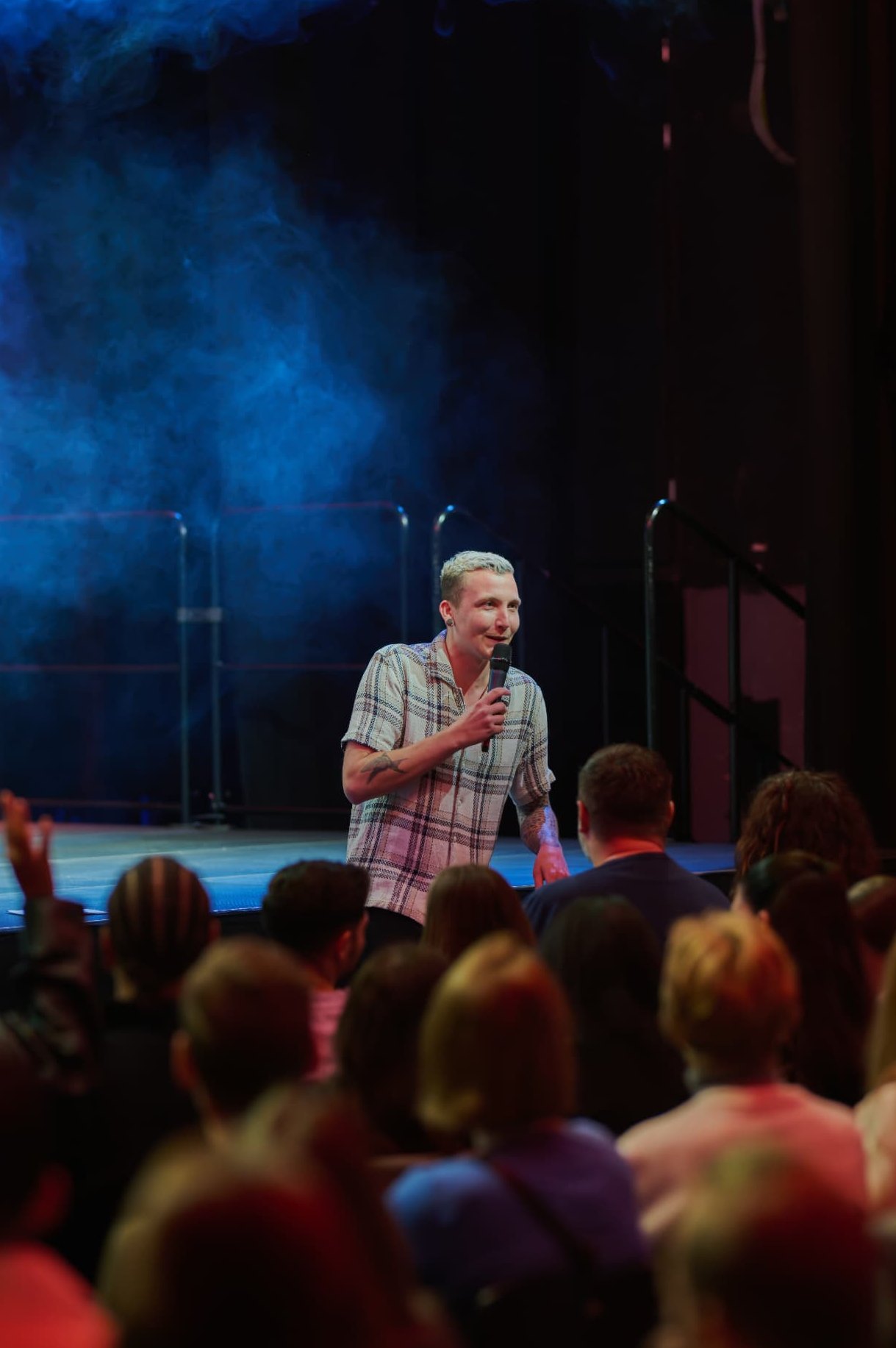 Comedian mit Mikrofon im blauen Bühnenlicht bei der Comedy X Show No Taboo